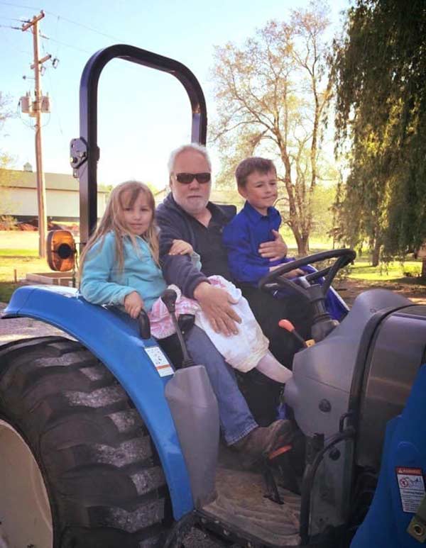roger on tractor with two kids